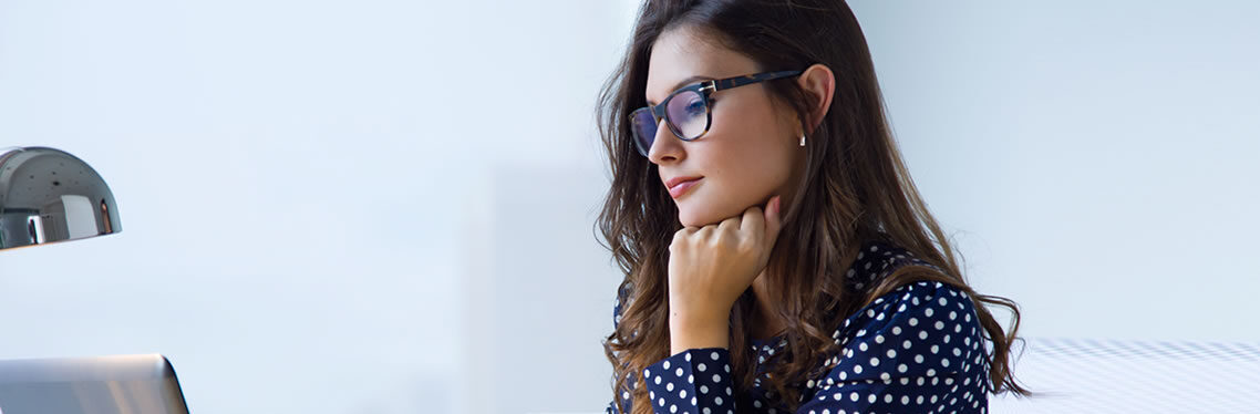 Woman in glasses working at a laptop taking an online Microsoft Outlook course